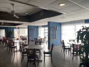 Enjoy meals in this spacious dining area with a high ceiling and large windows.