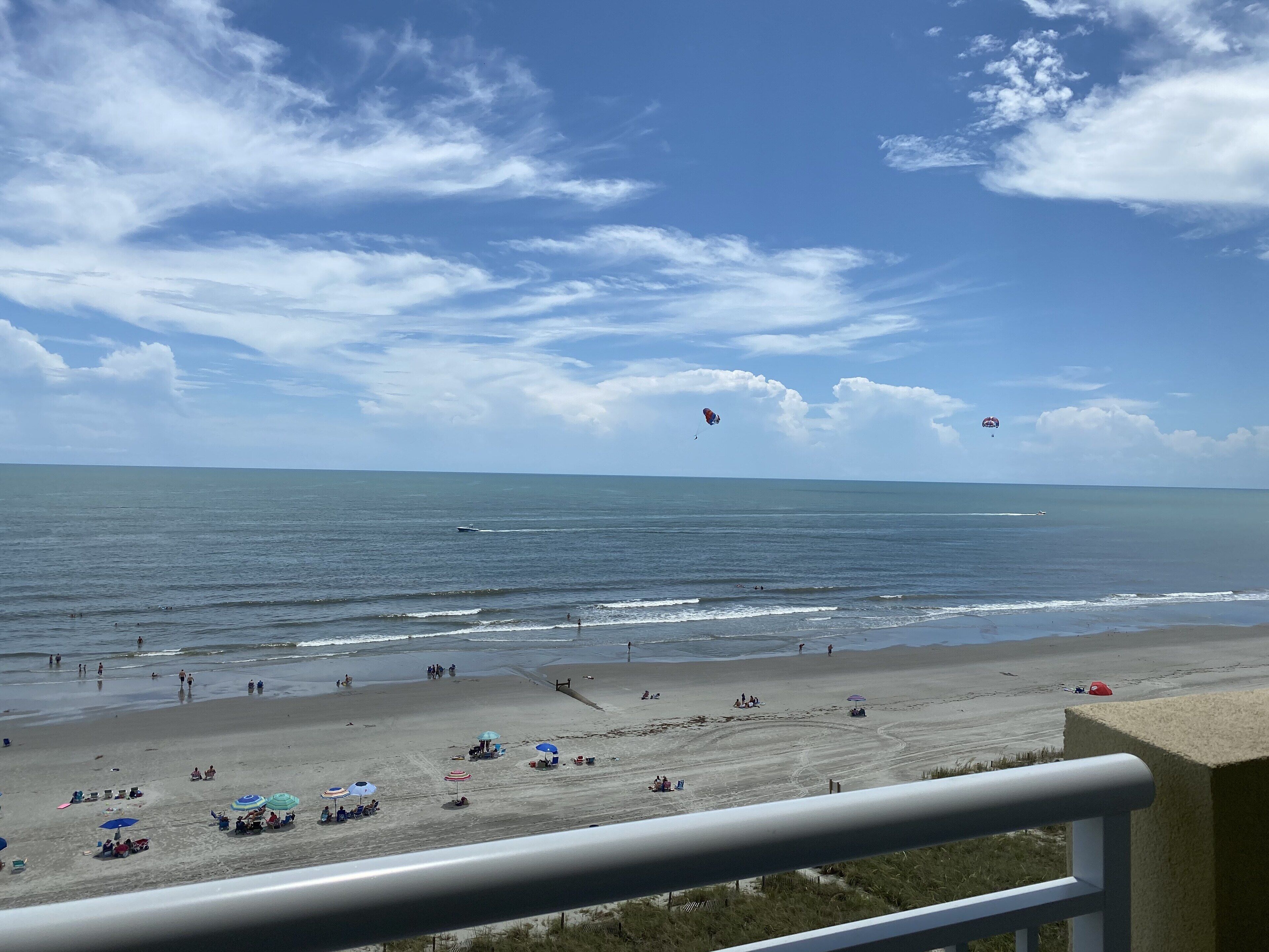 Una spiaggia con ombrelloni, persone e vista sull'oceano.