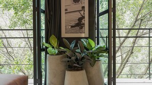 A modern room with large windows, potted plants, and framed pictures on the wall. - Modern 1BR Loft in the middle of Provenza (Medellín)
