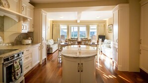 A spacious kitchen with a central island, wooden cabinets, and a dining area with a view. - Cottage 360 - Clifden - sleeps 6 guests  in 3 bedrooms (Clifden)