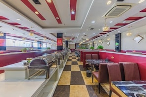 A restaurant with a checkered floor, red and white decor, and multiple seating areas.