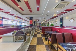 Un restaurante con suelo a cuadros, decoración en rojo y blanco, y varias zonas de estar.