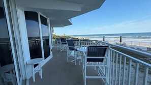 Ein Balkon mit weißen Geländern, Sitzgelegenheit und Meerblick.