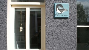 A building facade with a sign reading "Guillemet" and a bird logo.