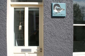 Guillemet's charming entrance features a stylized bird sign and a welcoming door.