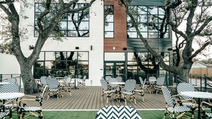 Een terras buiten met rieten meubilair en een houten terras.