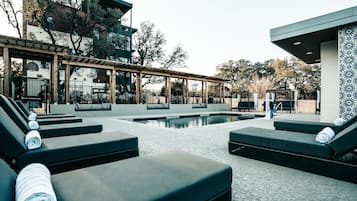 Una piscina al aire libre de temporada, sillones reclinables de piscina