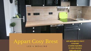 A modern kitchen with black cabinets, a microwave, and a sink.