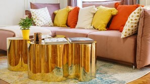 A living room with a pink sofa, gold side tables, and a yellow plant. - President - romantic design apartment in the centre of Prague (Hlavní město Praha)