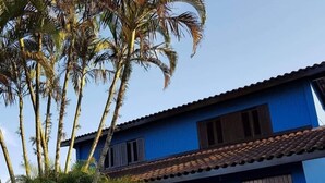Un edificio de dos pisos con fachada azul y techo de tejas.