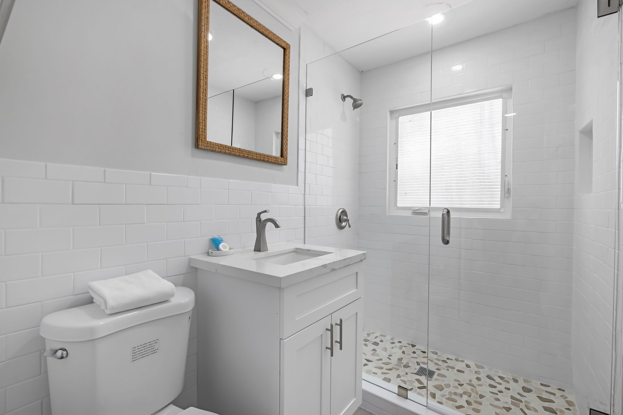 Un baño moderno con inodoro, lavamanos y ducha.