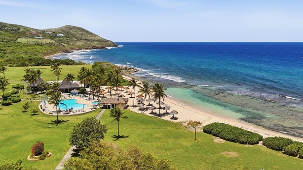 Um resort com piscina, praia e vista para o oceano.