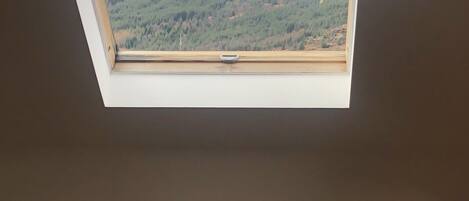 A skylight with a view of a mountainous landscape.