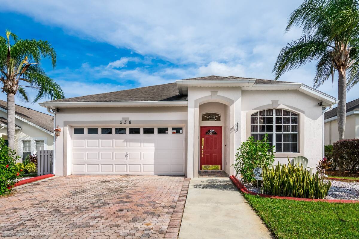 A single-story house with a white exterior, a red front door, and a garage numbered 536.