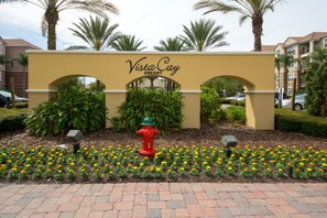 A sign for Vista Cay Resort with a red fire hydrant and flower beds in front. - Vista Cay Resort by Florida Star Vacations (Orlando)