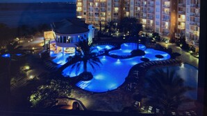 A resort with a large swimming pool, a palm tree, and a building with multiple balconies. - 5 Star Aruba Resort Christmas week! (Noord)