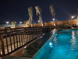 Una piscina al aire libre, sombrillas