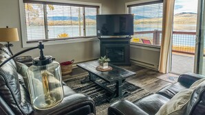 A living room with a fireplace, leather sofa, and a television. - Edgewater #5 Montana (Polson)