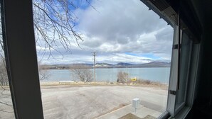 A view through a window of a parking lot with a lake and mountains in the background. - Edgewater #5 Montana (Polson)