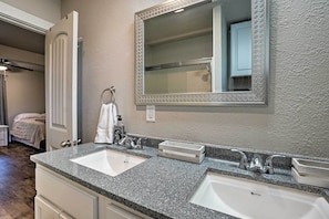 A bathroom with two sinks, a large mirror, and a towel rack. - Peaceful Broken Bow Cottage w/ Fire Pit! (Broken Bow)