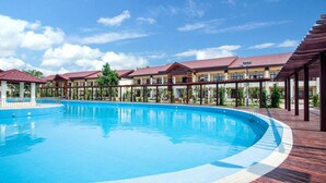 A large swimming pool surrounded by covered walkways and buildings with red roofs. - 36 Manor International Sport Hotel (Vientiane)