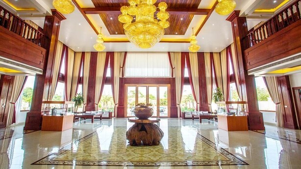 A spacious lobby with a large chandelier, a reception desk, and a decorative centerpiece. - 36 Manor International Sport Hotel (Vientiane)