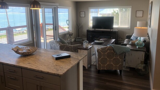 A cozy living area with a TV, comfortable seating, and a kitchen counter. - Edgewater #8 Scout (Polson)