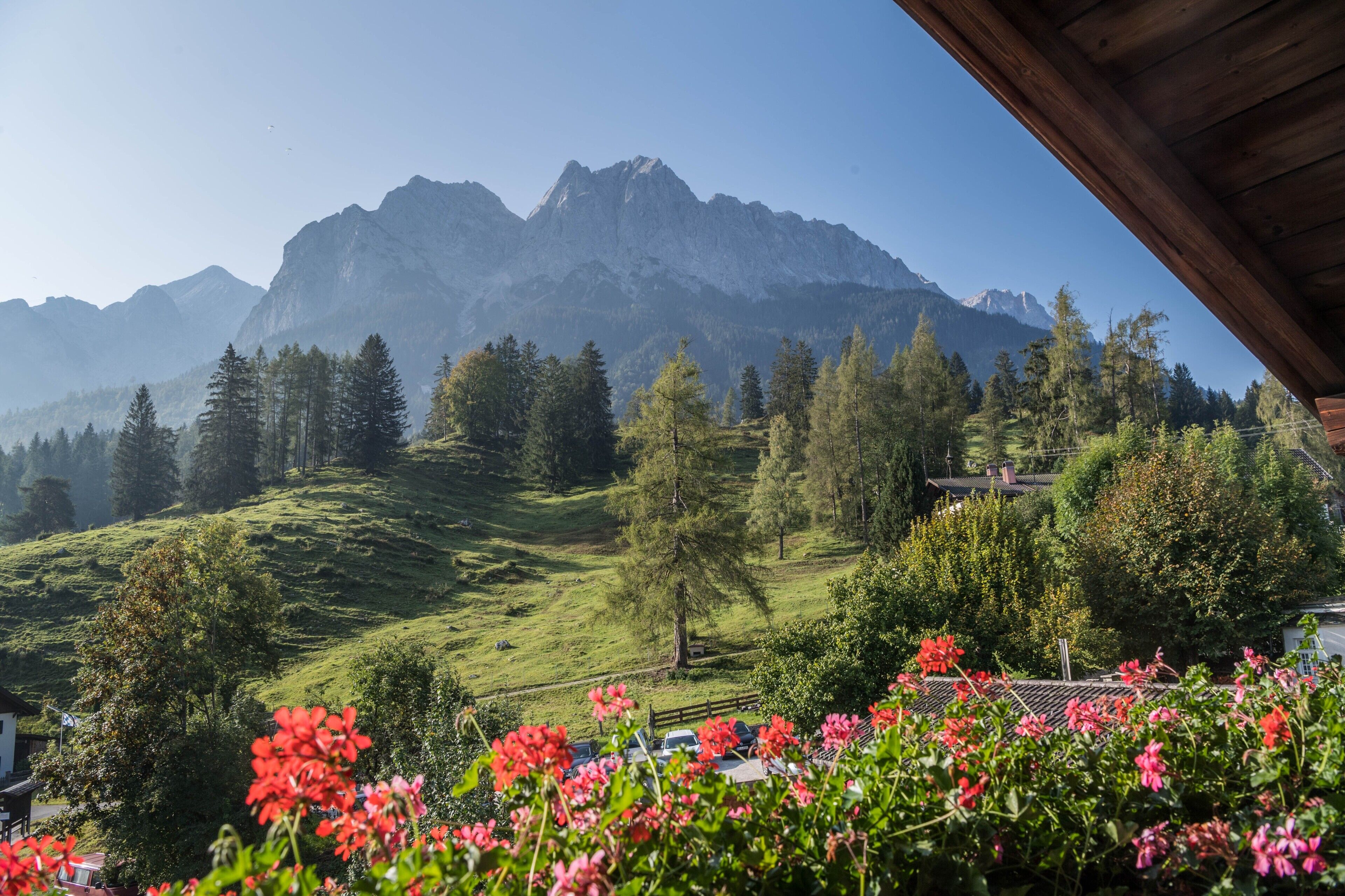 Un paysage montagneux avec, au loin, un bâtiment doté d’un toit en bois.