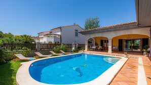 A swimming pool with lounge chairs, a patio area, and a house with a tiled roof. - “Ca Na Rosa” close to the Beach with Wi-Fi, A/C, Terrace, Garden & Pool (ALCUDIA)