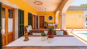 A wooden table with a white tablecloth, two potted plants, and a candle. - “Ca Na Rosa” close to the Beach with Wi-Fi, A/C, Terrace, Garden & Pool (ALCUDIA)
