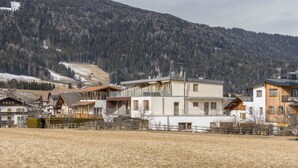 A residential area with modern houses, a clear sky, and a mountainous backdrop.