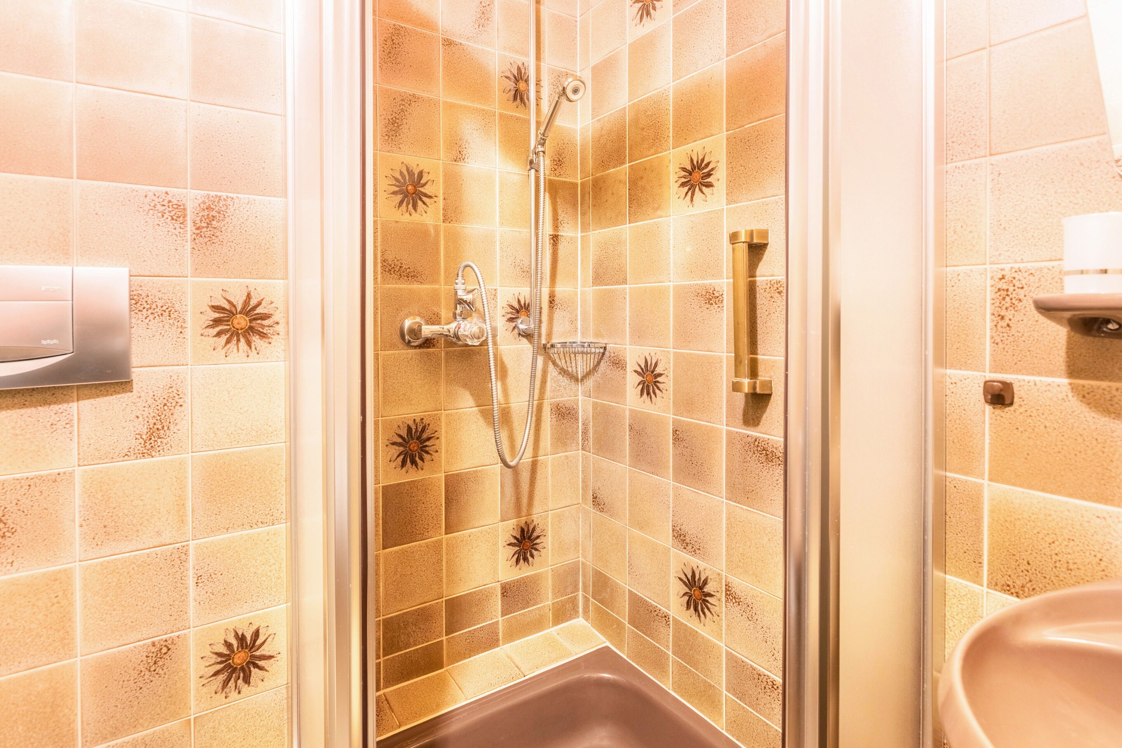 A shower with a handheld showerhead and a handheld showerhead with a rain shower attachment.