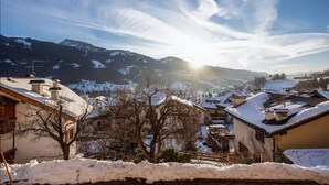 A snow-covered village with houses, a mountain range, and a clear sky. - Child-friendly Holiday Apartment "Cornon" with Mountain View, Sun Terrace & Wi-Fi (Tesero)