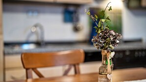 Una mesa de madera con un jarrón de flores y una botella.