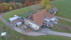 Vista aérea de una propiedad rural con una casa grande, un granero y un camino de entrada.