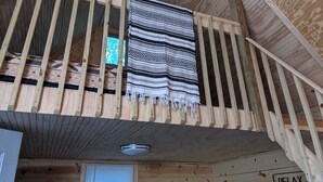 A wooden balcony with a striped blanket draped over the railing. -  Hocking Hills,Cozy Secluded Cabin,Minutes to Caves/WiFi/Pet Friendly! (McArthur)