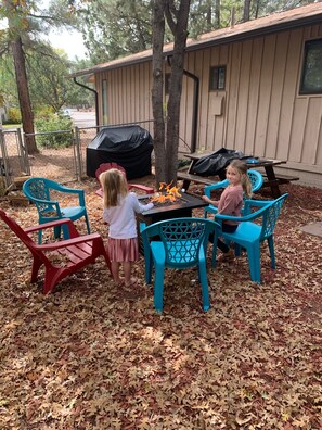 An outdoor seating area with a fire pit, surrounded by chairs and covered by a tarp. - Mountain Retreat a property in the cool pines of Show Low, AZ.  (Show Low)
