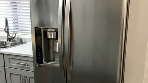 Ein Edelstahl-Kühlschrank mit Wasserspender und digitaler Bedienkonsole.