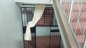 A staircase with metal railings, a sign indicating "2nd Floor Rooms 9-11", and a curtain partially covering a door.