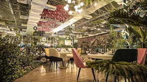 Un espace intérieur doté d’un plafond haut, d’un plancher en bois et de plusieurs coins salon.