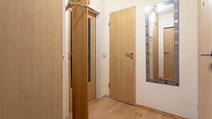 A hallway with wooden doors and a mirror on the wall. - Family & dog-friendly vacation apartment Hahnenklee with balcony near hiking trails (Goslar)