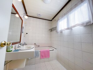 Bathroom with a window, sink, and mirror.