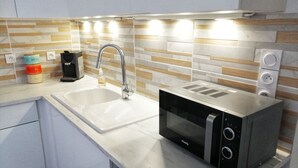 A modern kitchen with a built-in microwave, a sink, and a coffee maker.