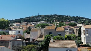 A hillside residential area with terracotta-tiled roofs and a mix of building styles.