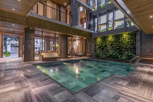 Una piscina techada, sillones reclinables de piscina