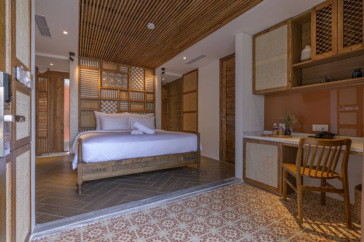 A bedroom with a bed, a desk, and a chair.