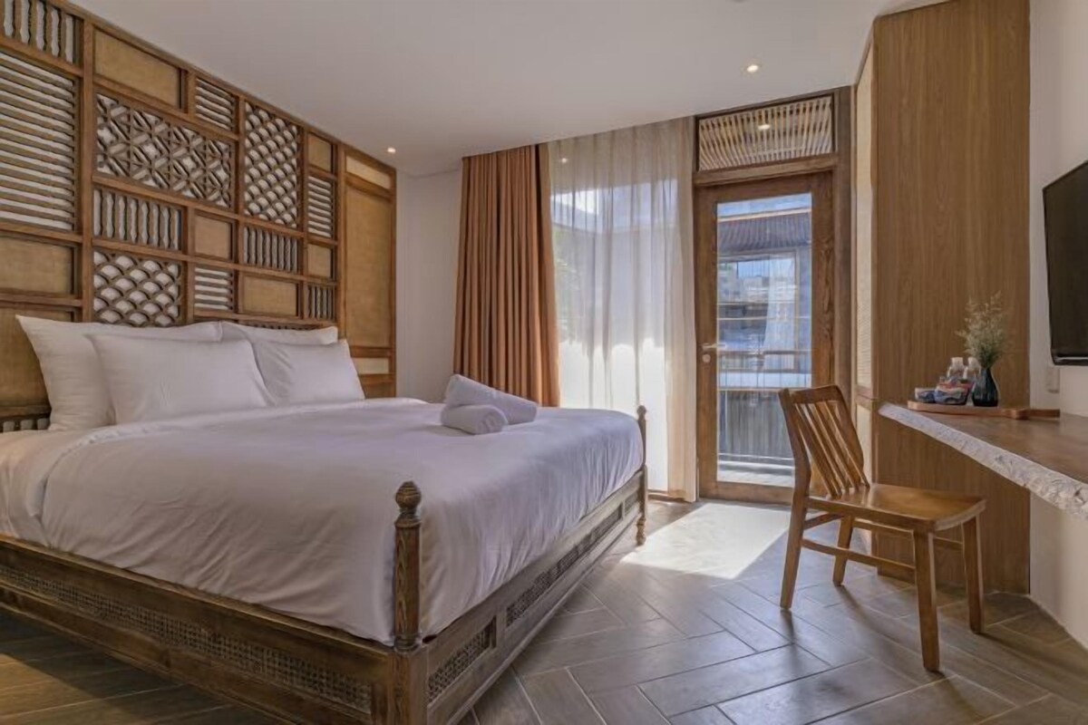 A bedroom with a wooden bed, a desk, and a chair.