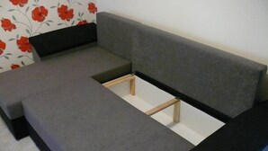 A room with a grey sofa, a wooden bench, and a floral wallpaper. - ⭐B and R Serviced Accommodation and Apartments Amesbury⭐ Archer house  (Amesbury)
