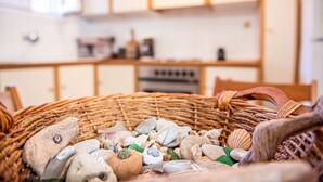 A wicker basket filled with various stones and shells. - Pine Trees Apartment (Preveza)
