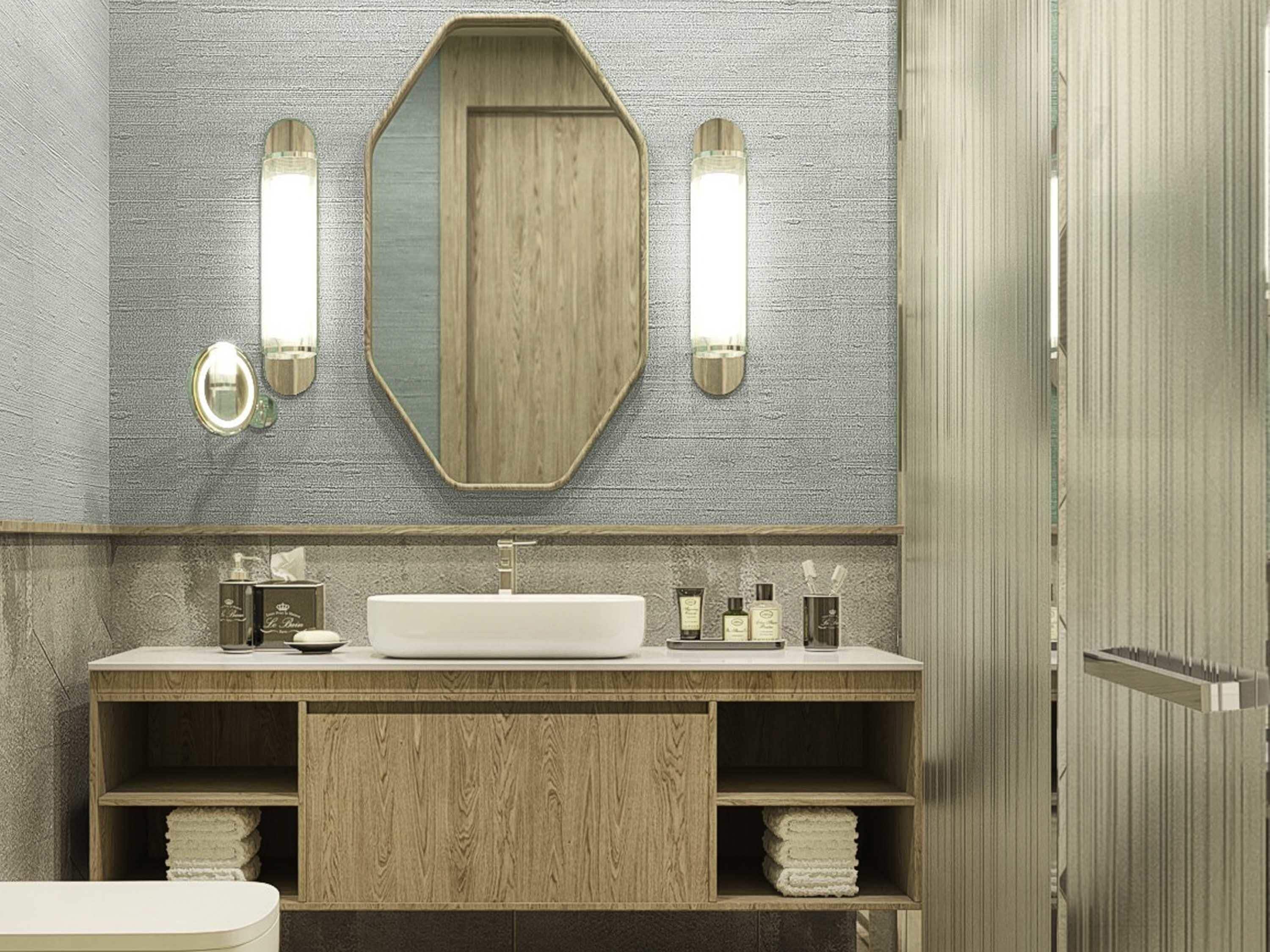 A bathroom with a wooden vanity, a large mirror, and two wall-mounted lights.